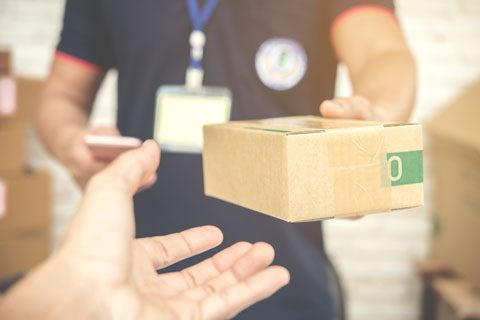 delivery-man-smiling-holding-cardboard-box.jpg